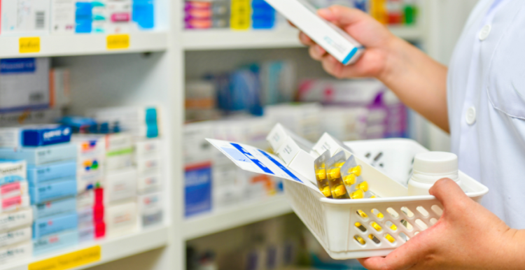 a pharmacist grabbing medicines from a shelf