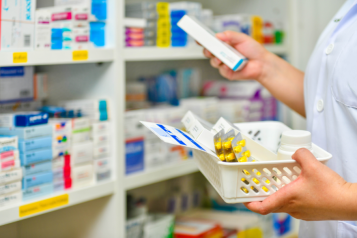 a pharmacist grabbing medicines from a shelf