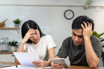 Man and woman reading a letter and stressed